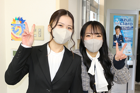 笑顔でVサインをする若手女性スタッフ2名