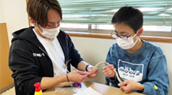 子どものやってみたいという気持ちを尊重し一緒に工作をするスタッフ